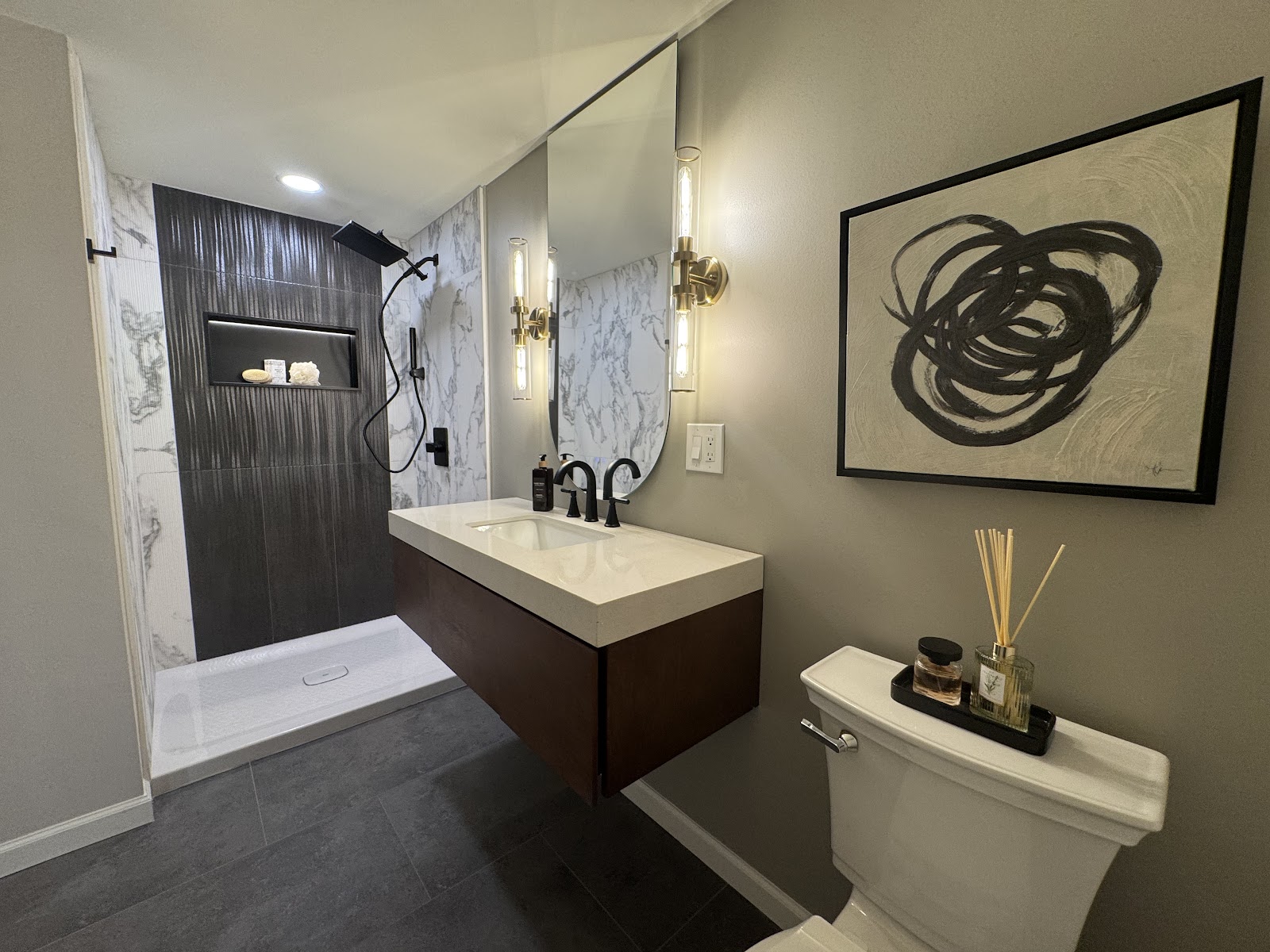 Finished bathroom with a tiled walk-in shower, floating vanity and black fixtures plumbed by Platinum Plumbing